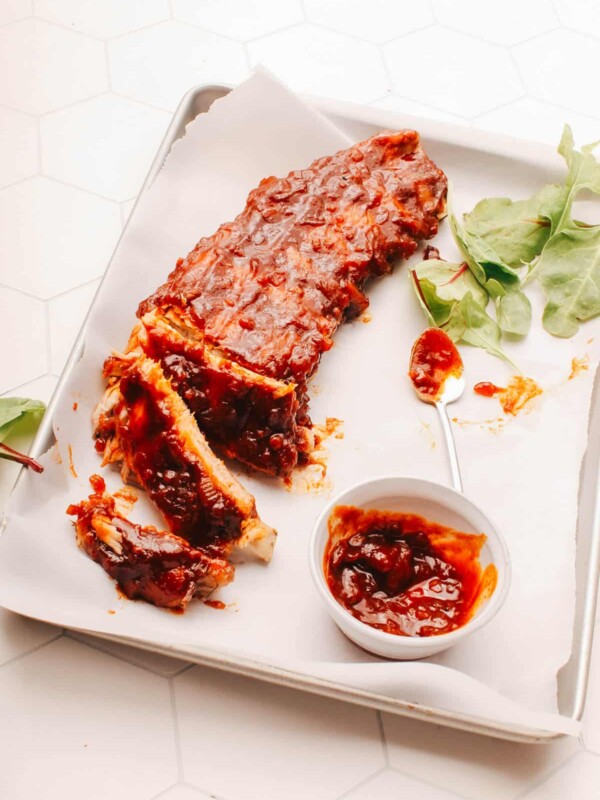 Spicy Sticky ribs on a plate with extra sauce.