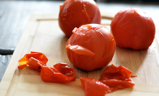 Peeling fresh tomatoes for sauce.