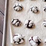 Chocolate Snowball Cookies baked on parchment-lined baking sheet.