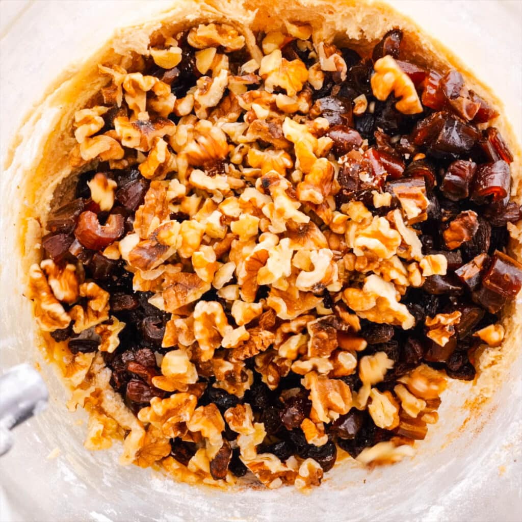 Nuts and Dried Fruit being added to hermit cookie dough.