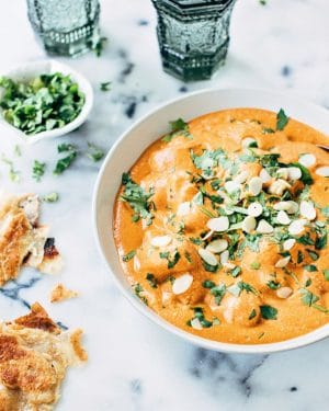 Homemade Paneer Butter Masala in a bowl topped with cilantro and almonds.