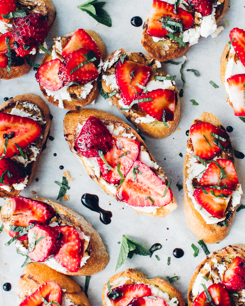 Crunchy crostini topped with sliced strawberries and fresh goat cheese