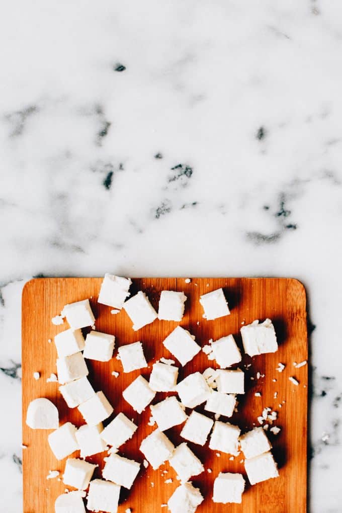 cubes of homemade paneer on a cutting board