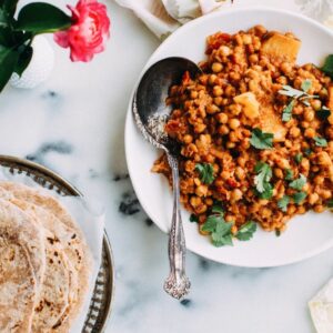 Chickpea curry with phulka roti on a plate.