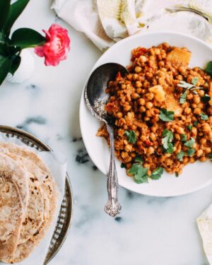 Chickpea curry with phulka roti on a plate.