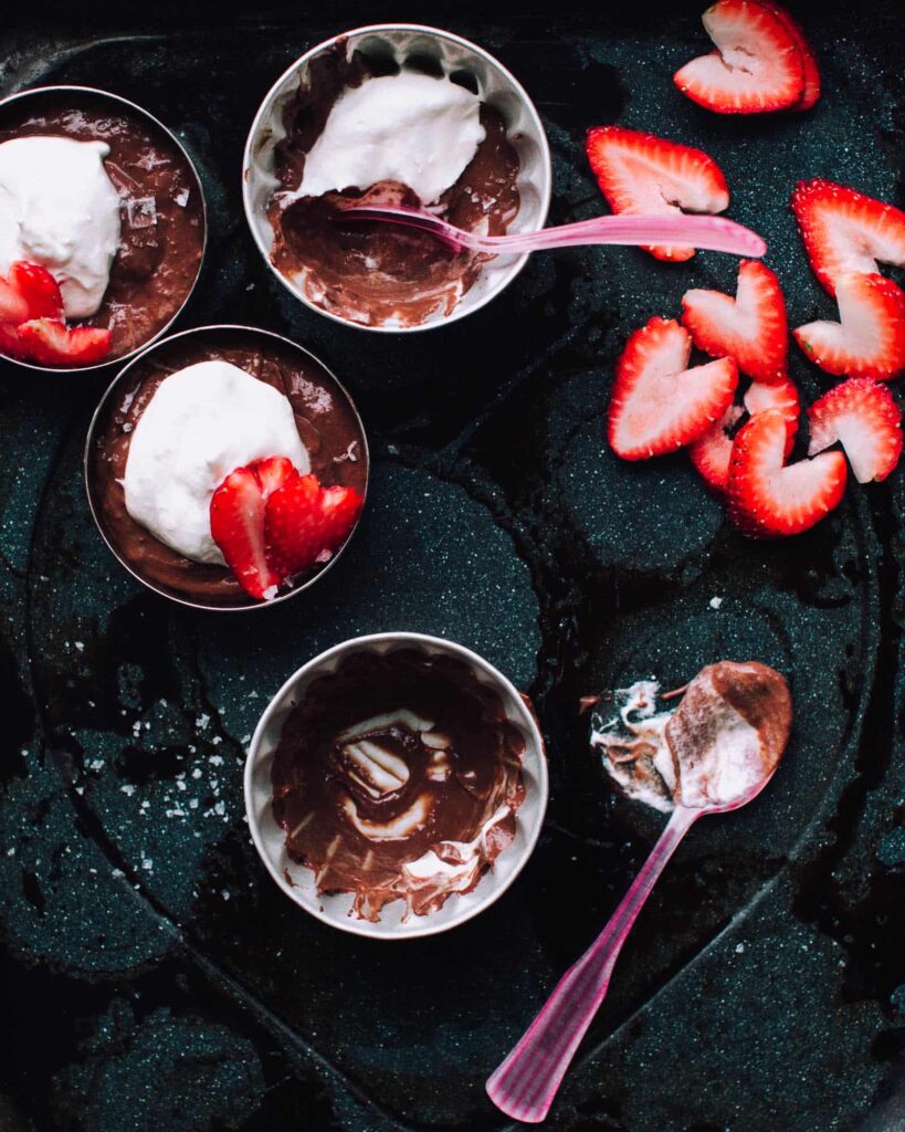 Salted Double Chocolate Pudding in a bowl with sliced strawberries on top