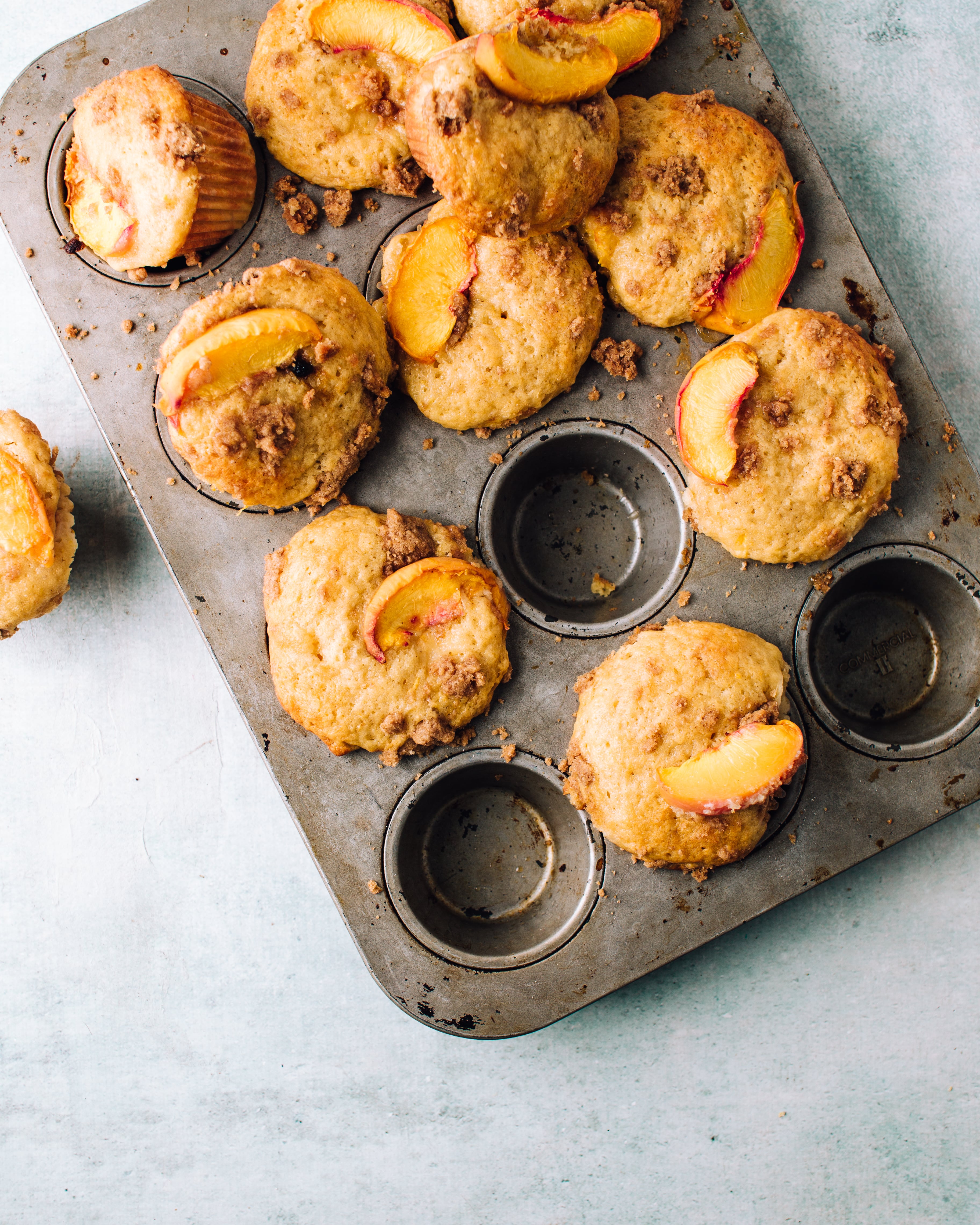 peach muffins in a muffin tray