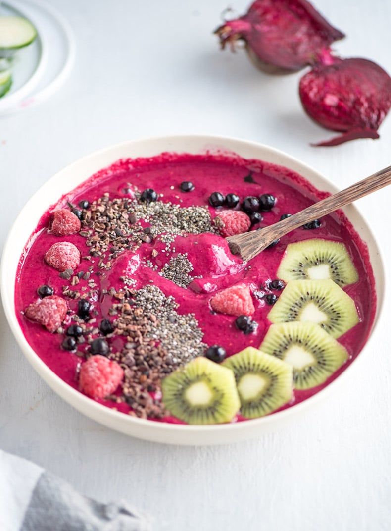 strawberry beet smoothie in a bowl topped with kiwi