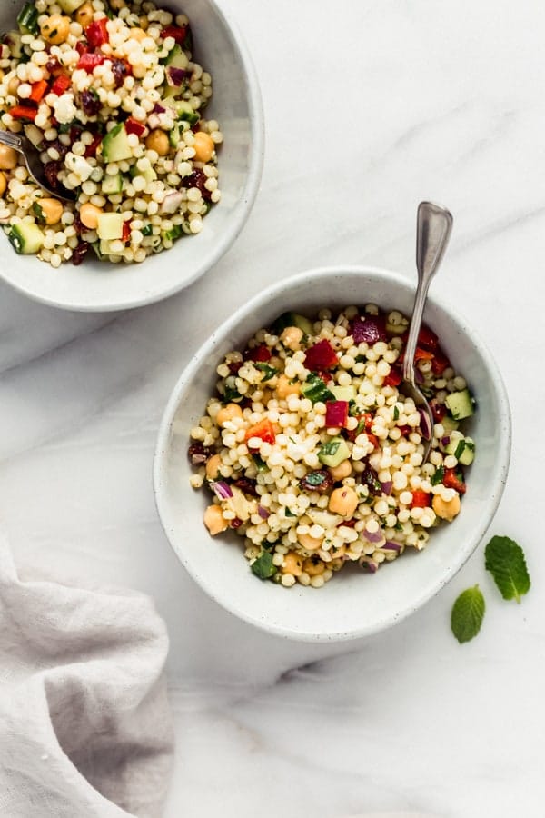 Israeli couscous salad with chickpeas and avocado on a plate.