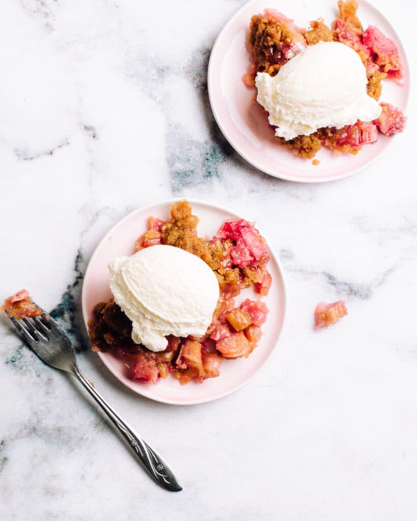 Easy Rhubarb Crisp on plates with ice cream.