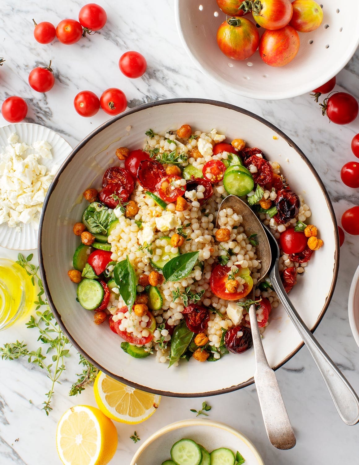 Israeli couscous salad with cherry tomatoes and basil on a plate.