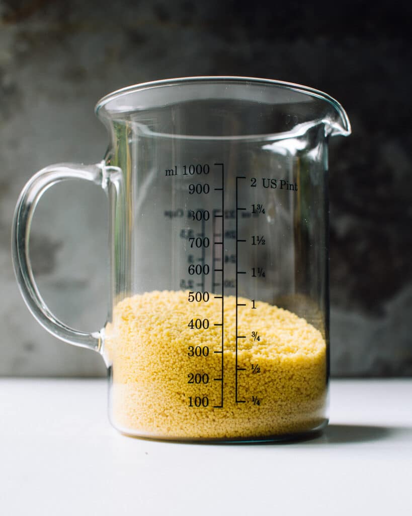 dry couscous in a measuring cup.