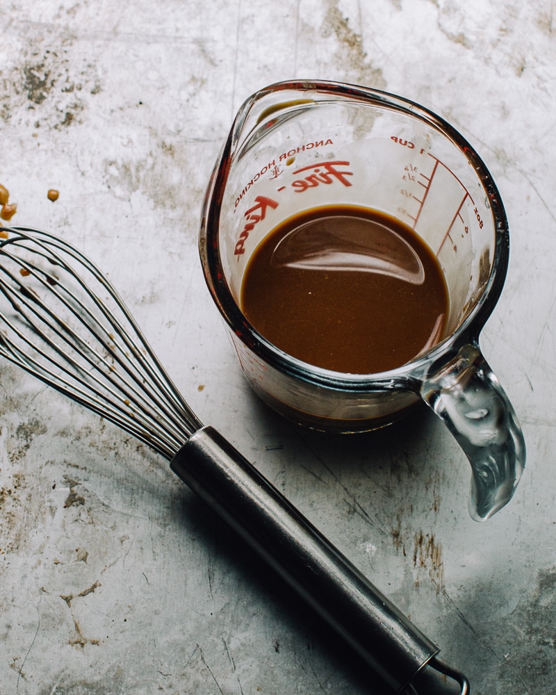 Stir fry sauce in a measuring cup with a whisk.