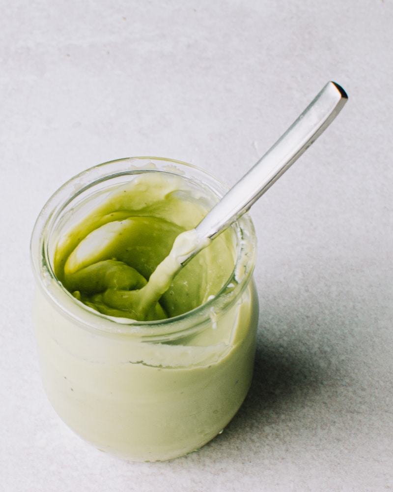 Perfect Avocado Crema in a jar with a spoon.