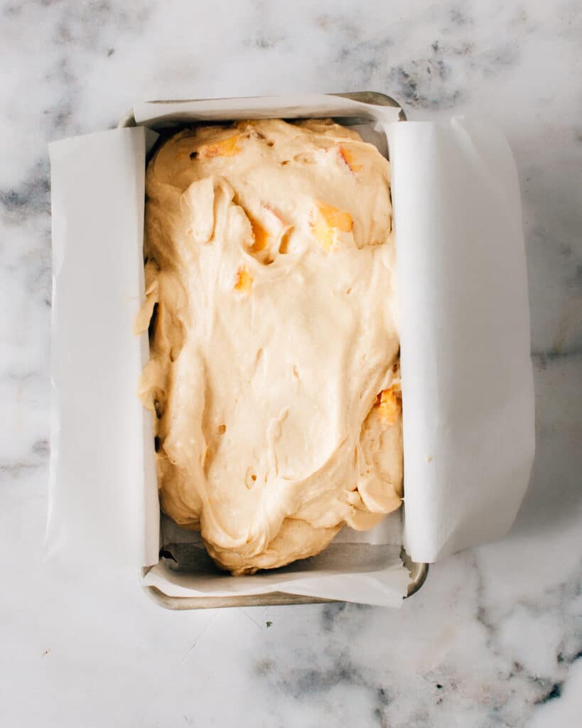 Peach pound cake batter in a loaf pan.
