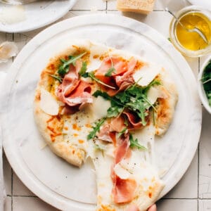 Prosciutto Pizza with Arugula is super easy to whip up, with olive oil and garlic in lieu of a sauce. It is layered with texture and flavour.