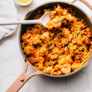 Chorizo paella in a pan with a serving spoon.