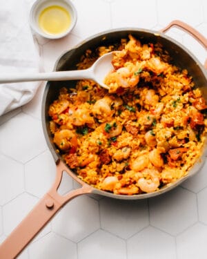 Chorizo paella in a pan with a serving spoon.