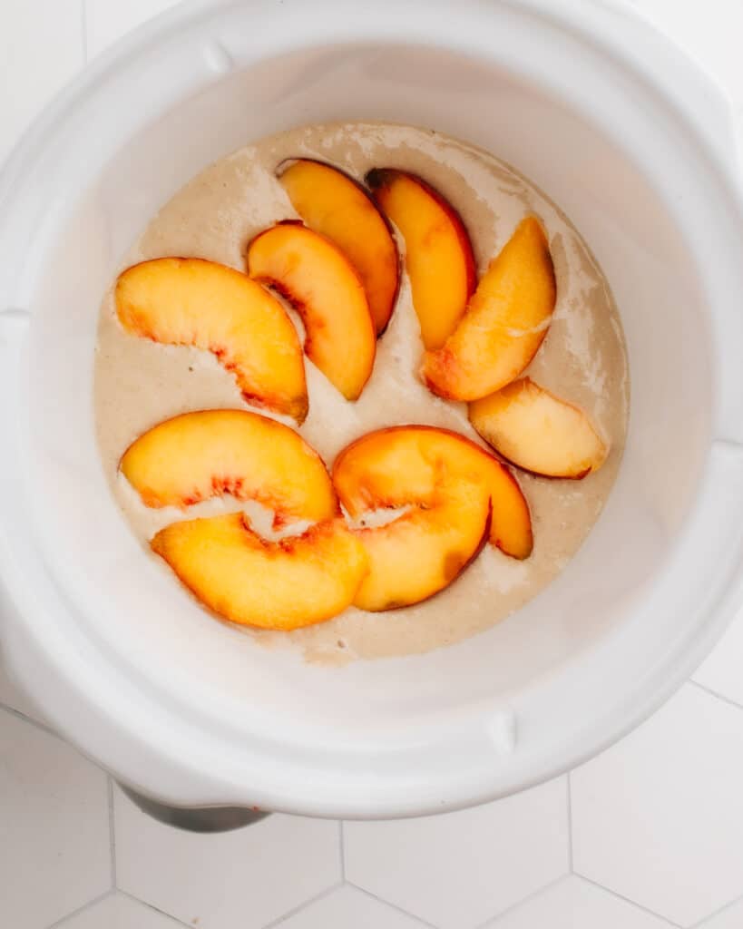 These Crockpot™ Slow Cooker Baked Oats are such an easy way to get breakfast on the table quickly in the morning. Made overnight, my version of this viral TikTok baked oatmeal recipe features juicy peaches. Feel free to swap in any other in-season fruit (or even chocolate chips!). 
