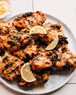 Grilled Honey Mustard Chicken on a plate with lemon slices.