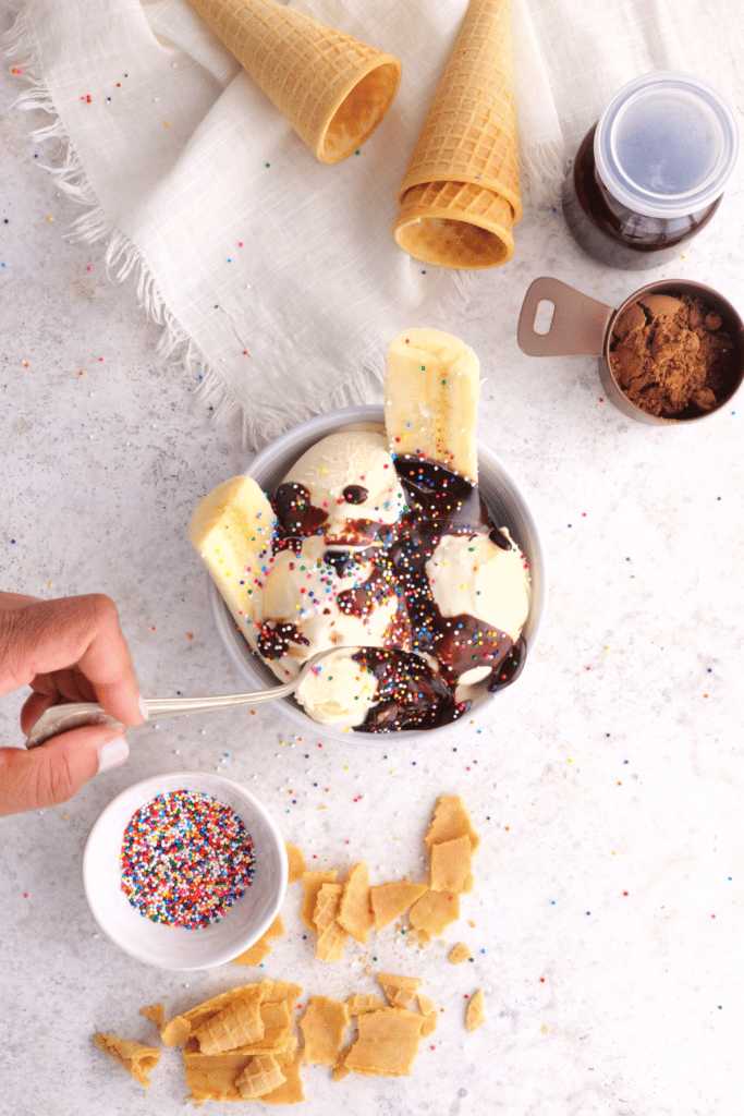vanilla ice cream with chocolate hot fudge on a bowl, being scooped