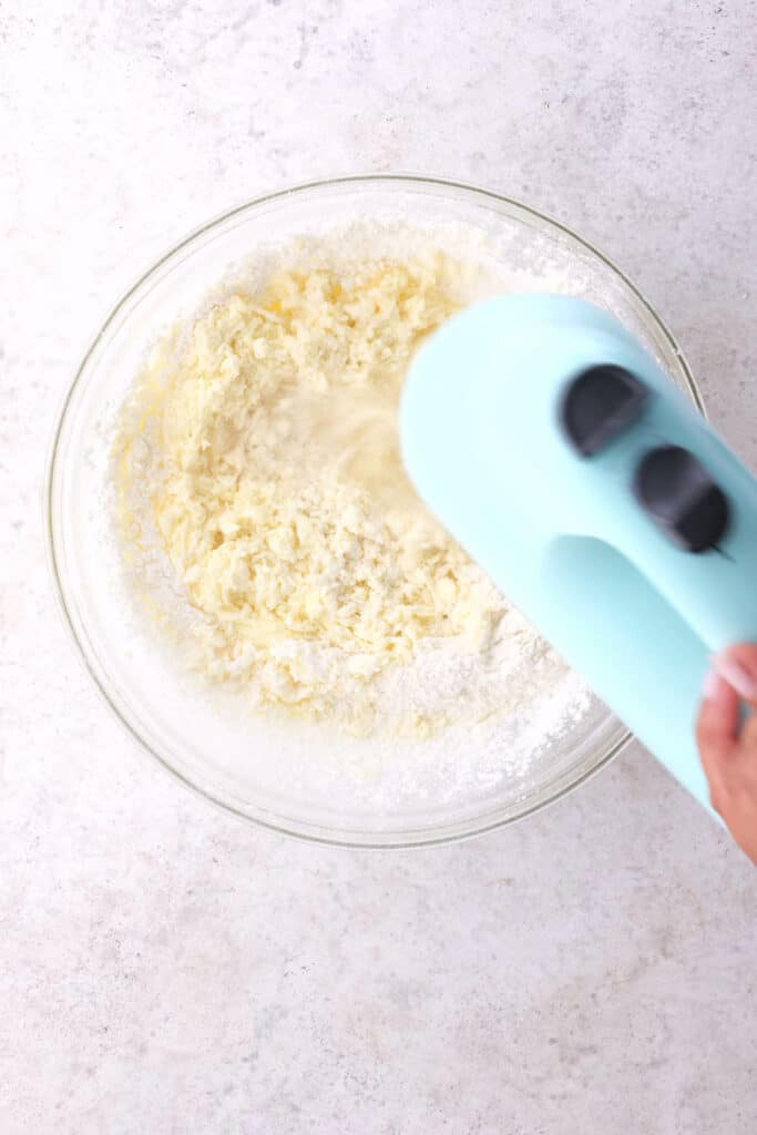 Beating flour into the dough with hand mixer.