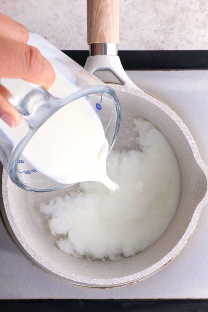 adding milk to hot water
