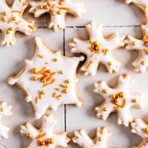 Snowflake cookies with royal icing and sprinkles on a table.