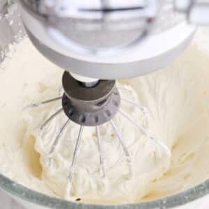 Whipping vanilla buttercream frosting in a stand mixer.