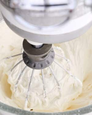 Whipping vanilla buttercream frosting in a stand mixer.