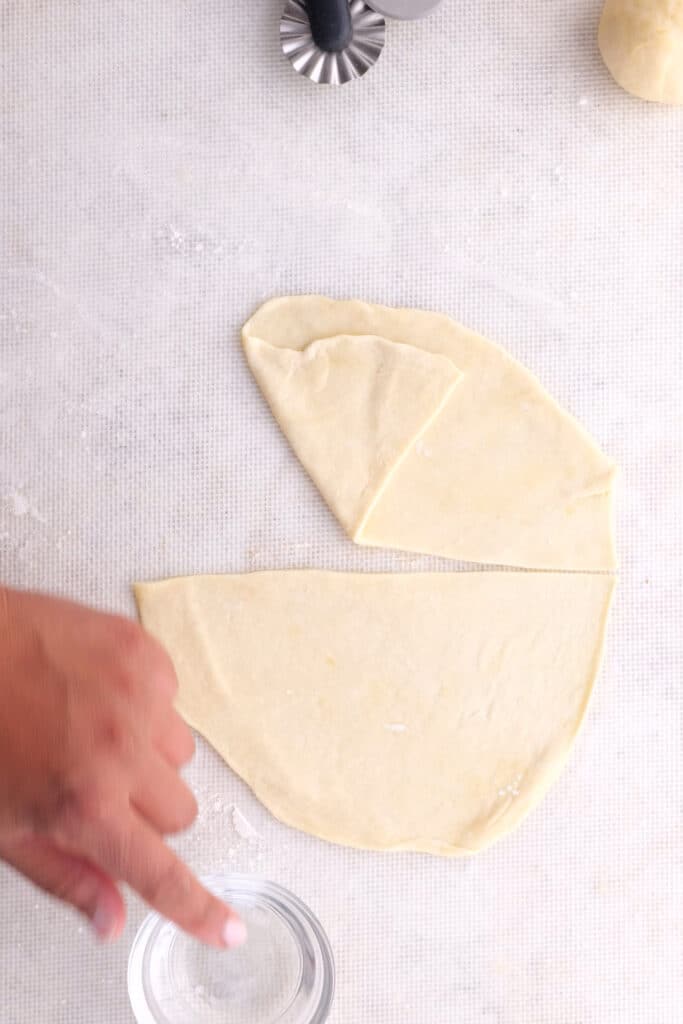 Cutting the flattened dough in half