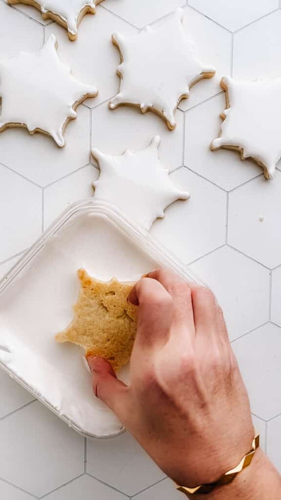 Dunking snowflake cookie in royal icing.