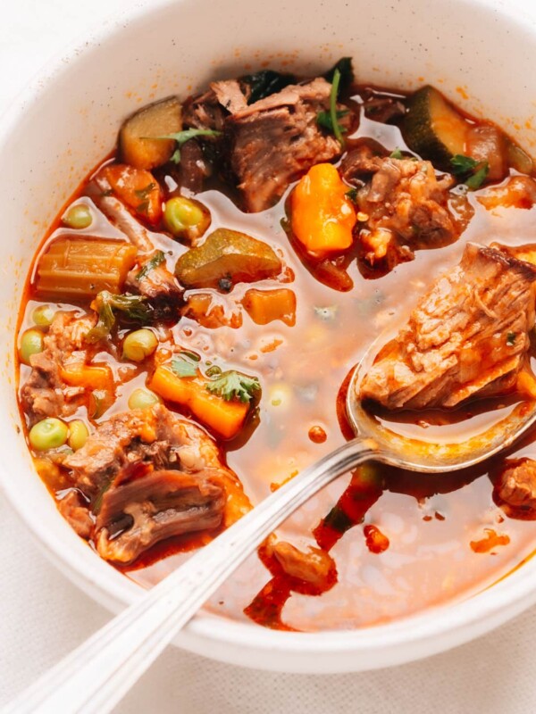 Close up photo of a spoonful of beef vegetable soup.