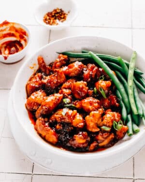 Gochujang chicken and green beans in a shallow bowl ready to enjoy.