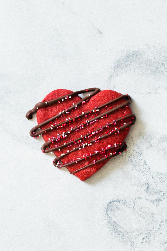 heart shaped red velvet cookie drizzled with melted chocolate