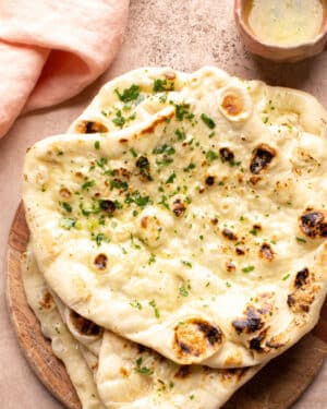 Warm butter naan with a dish of melted butter.