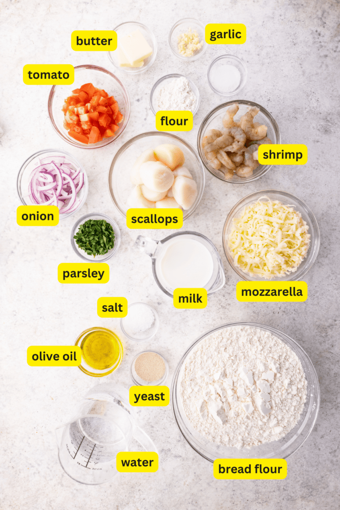 Seafood pizza ingredients arranged on a kitchen countertop