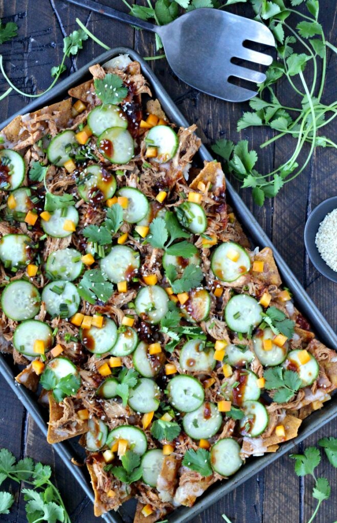 Top view of pulled chicken nachos with a serving spoon