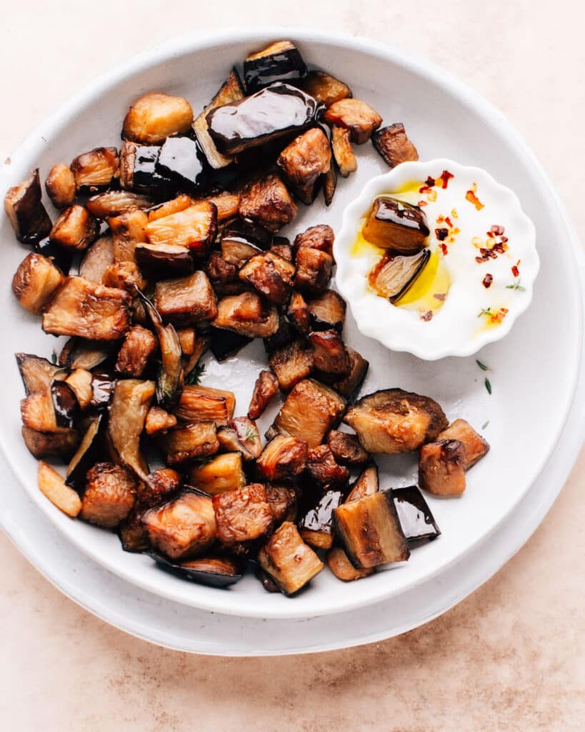 Crispy air fried eggplant served on a plate with a delicious and creamy Greek yogurt dip