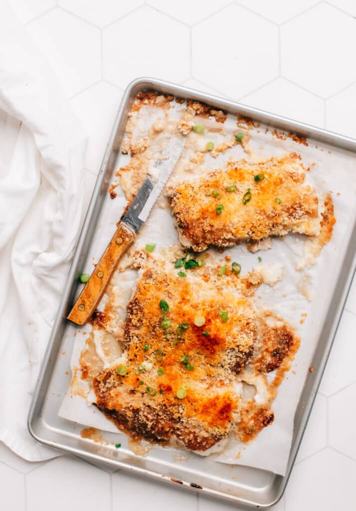 Delicious-looking freshly baked panko crusted cod, sizzling on a baking sheet
