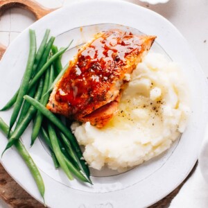 Cajun Honey Butter Salmon on mashed potatoes with green beans.