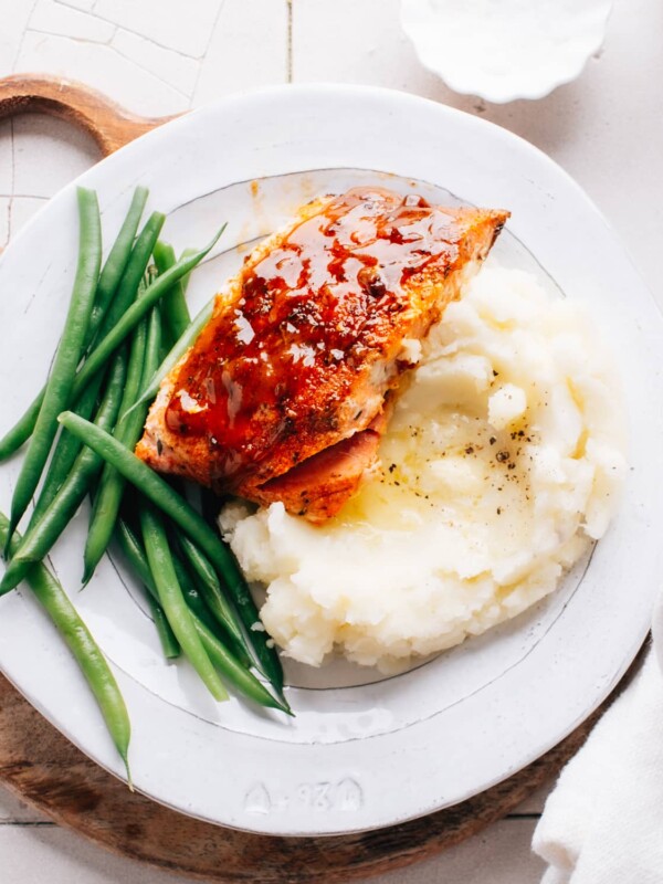 Cajun Honey Butter Salmon on mashed potatoes with green beans.