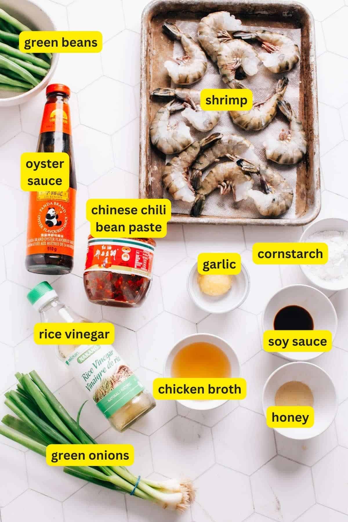 Ingredients for hunan shrimp on a kitche countertop including shrimp
chinese chili bean paste, soy sauce, rice vinegar, oyster sauce, honey, cornstarch, chicken broth, garlic, green beans and green onions.