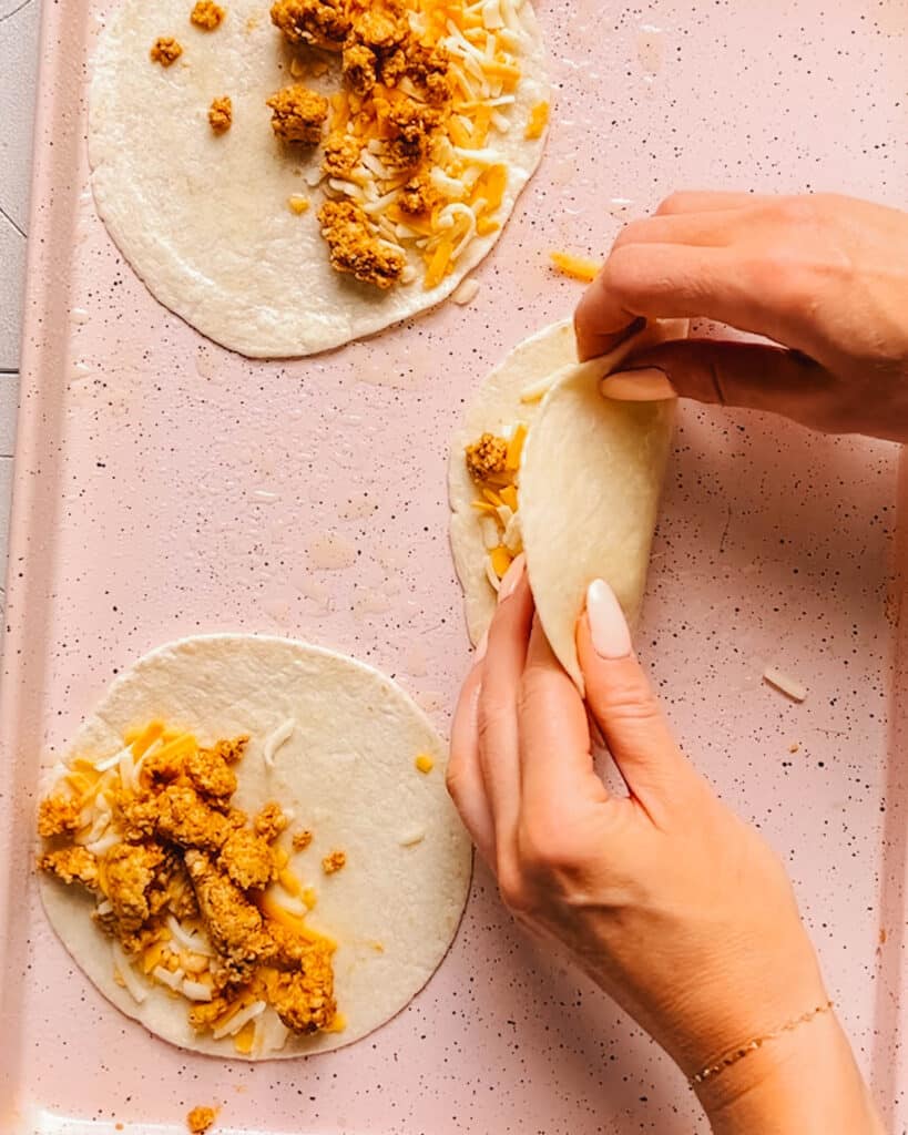 Assembling tacos with ground chicken using homemade chicken taco seasoning.