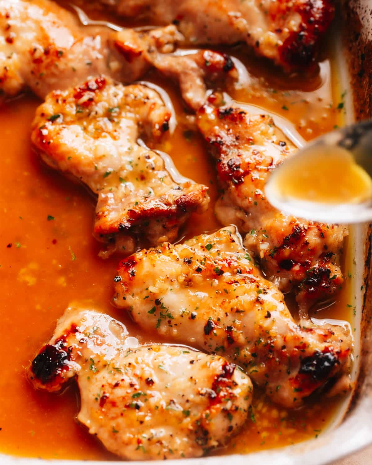 Juicy honey garlic lemon pepper chicken thighs arranged in a baking dish