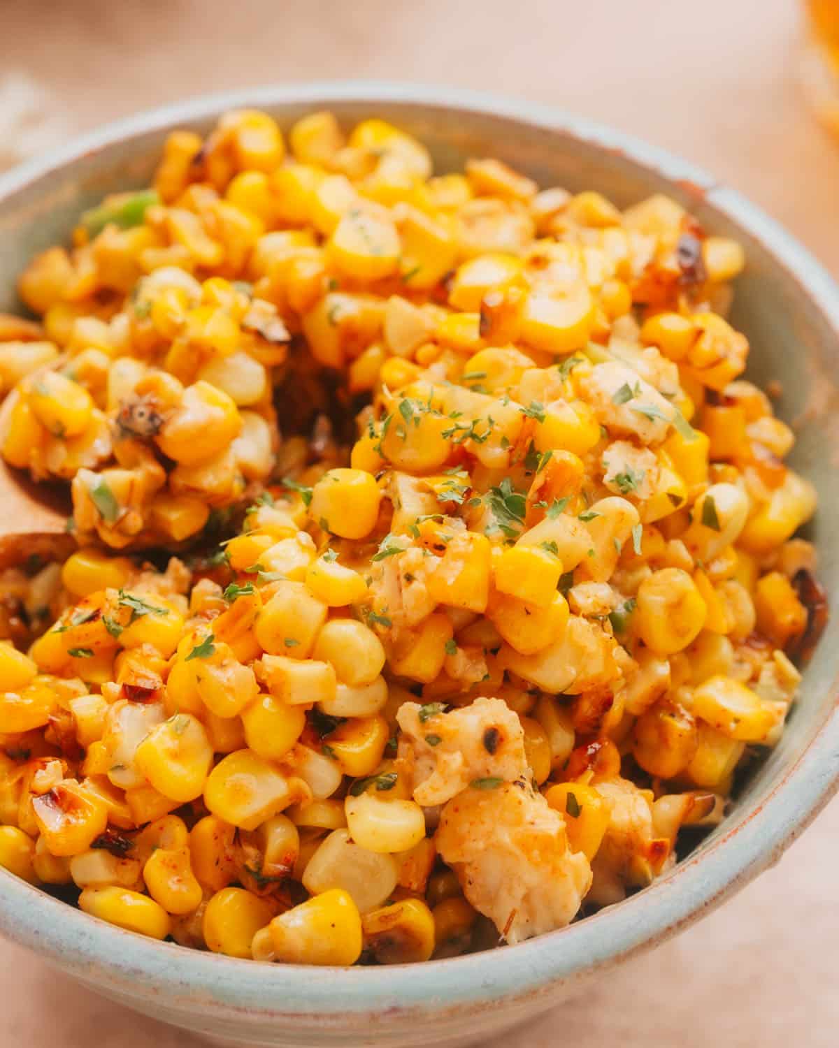 A bowl of Mexican Corn in Cup Street Corn Salad (Esquites) garnished with fresh cilantro.