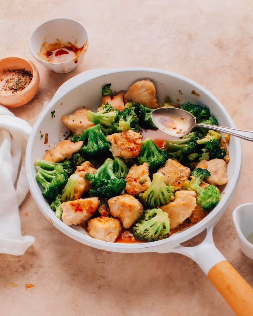 The chicken and broccoli stir fry is cooked in a large skillet.