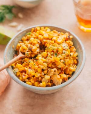 Mexican street corn salad (esquites) in a bowl with a spoon.