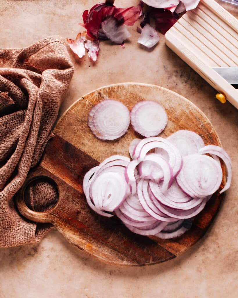 Sliced onions on a wooden cutting board