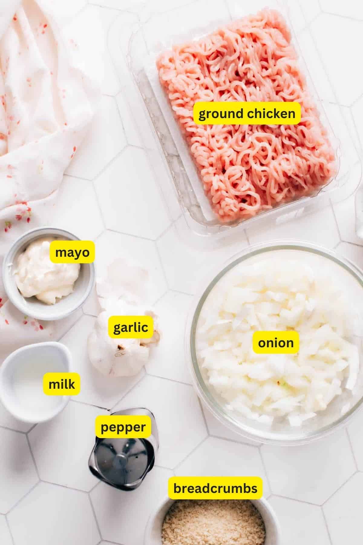 Ingredients for ground chicken burgers, including ground chicken, breadcrumbs, garlic, mayo, onion, pepper, and milk.